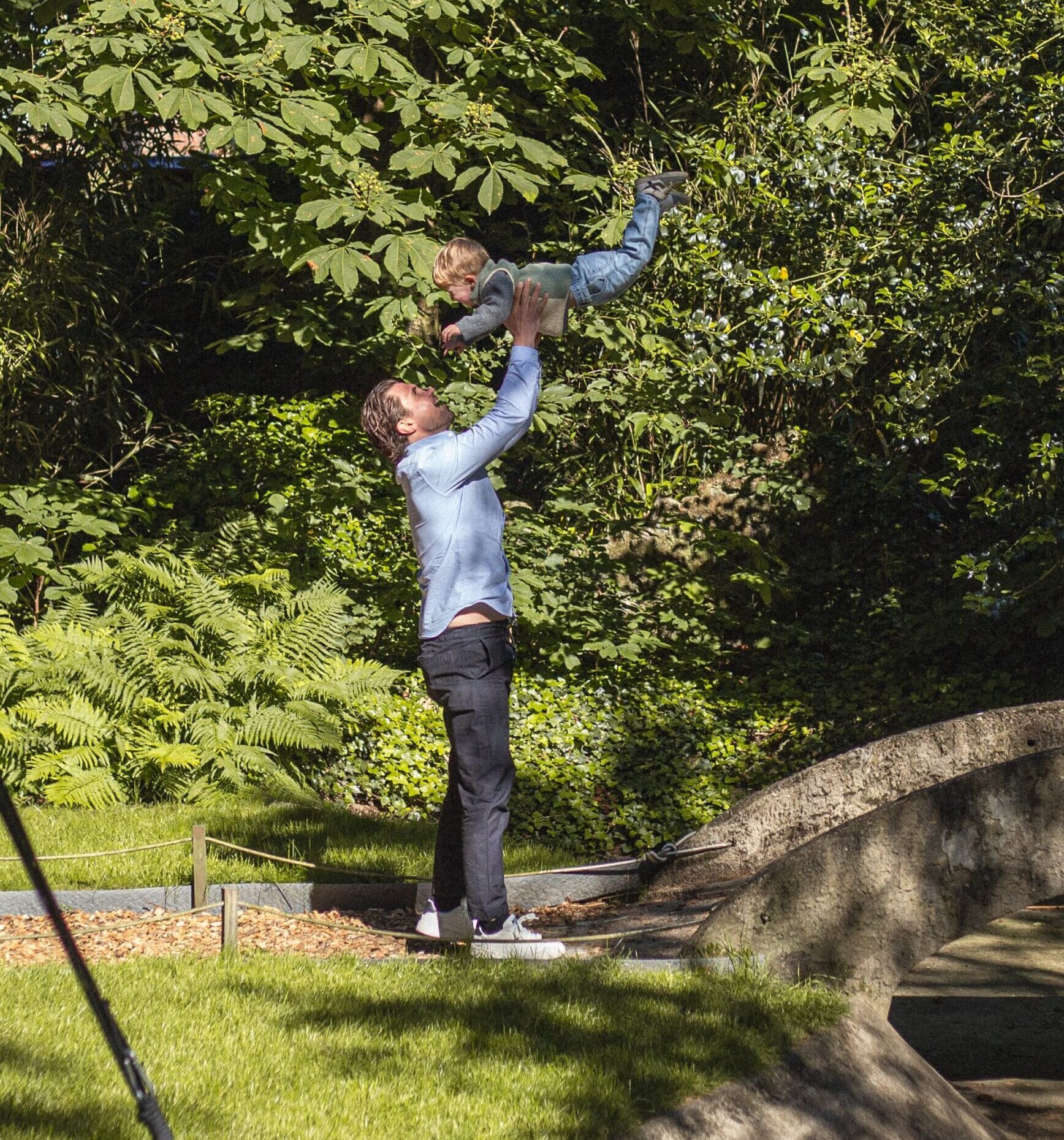 Vader die met kind speelt in de tuin van Alix