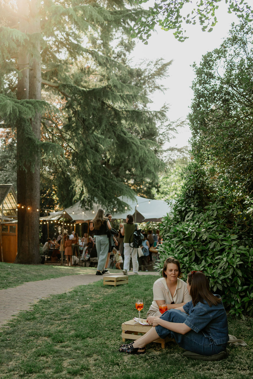 Twee vrouwen genieten in een mooie tuin met een glaasje aperol
